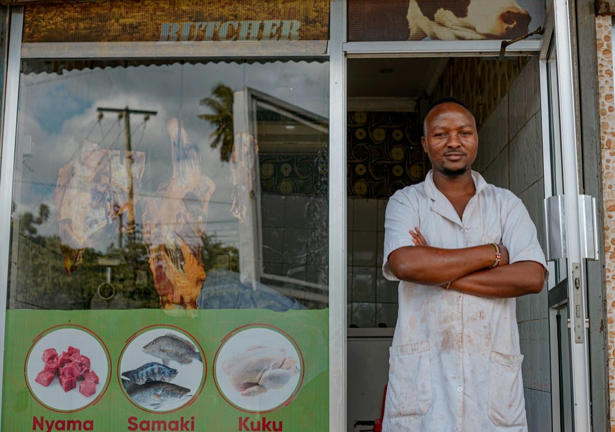 A butcher standing in the doorway of his shop