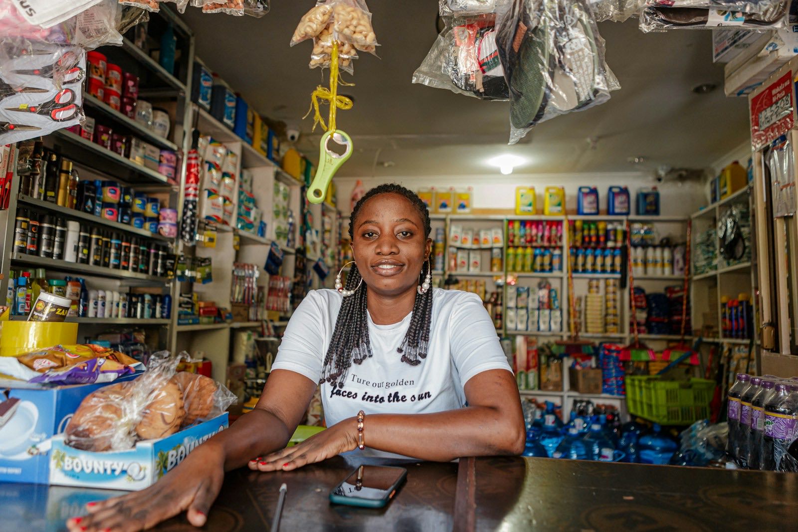 A shop owner behind the counter of her well-stocked retail shop